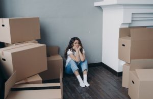 La Gestion Du Stress Lors d’Un Déménagement : Conseils Pratiques femme-stressee-assise-dans-un-coin-pendant-son-demenagement